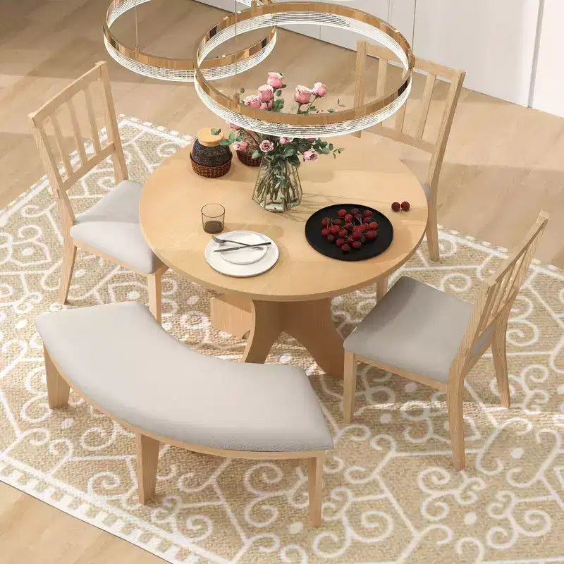 Ensemble table et chaises de salle à manger rondes de style campagnard, comprenant des chaises rembourrées et un banc incurvé.